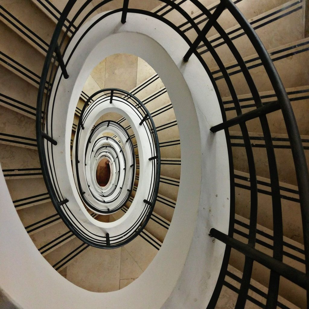 Photo prise du dessus d'un escalier en spirale qui induit un état d'hypnose léger si on le fixe