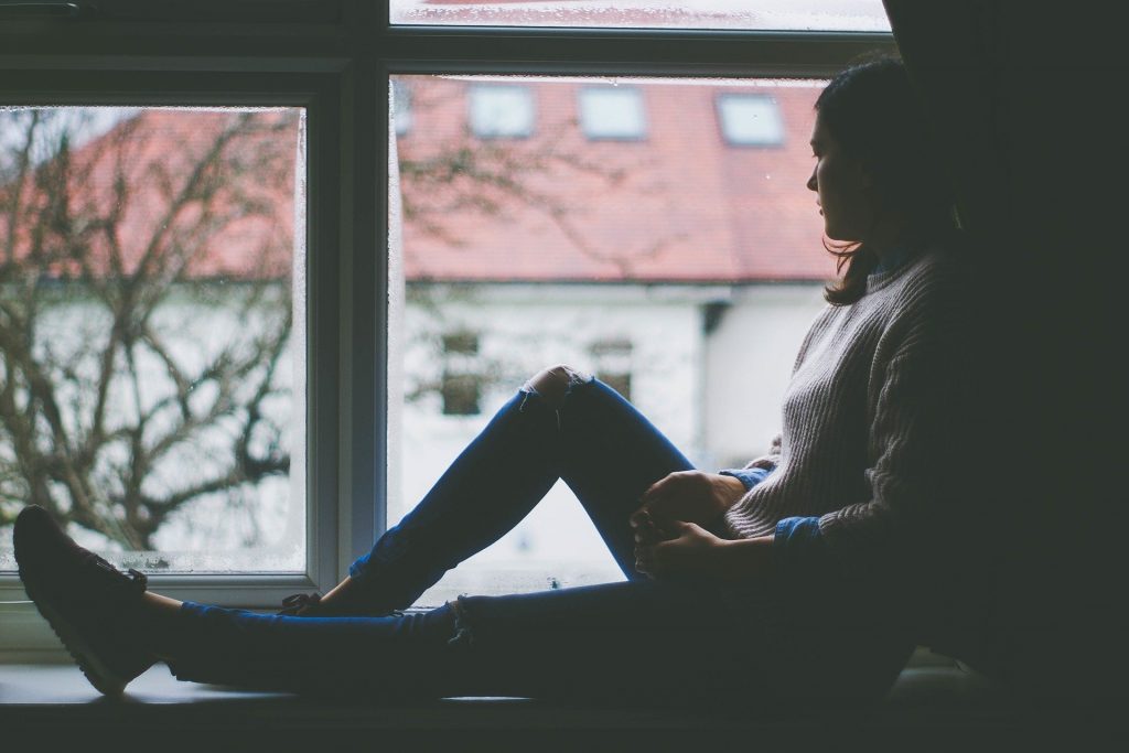 photo d'une femme au bord de la fenêtre en pleine dépression